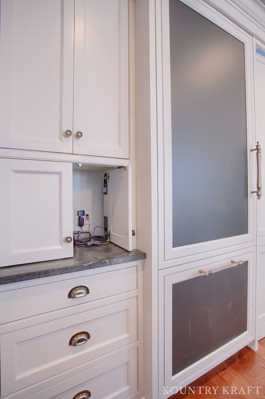 Hidden Outlets Camouflaged in a Charging Station in Extra White Kitchen Cabinets