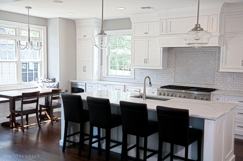 A Custom Range Hood and Cabinetry Create a Kitchen Focal Point A custom range hood design finished in a white paint creates the kitchen focal point