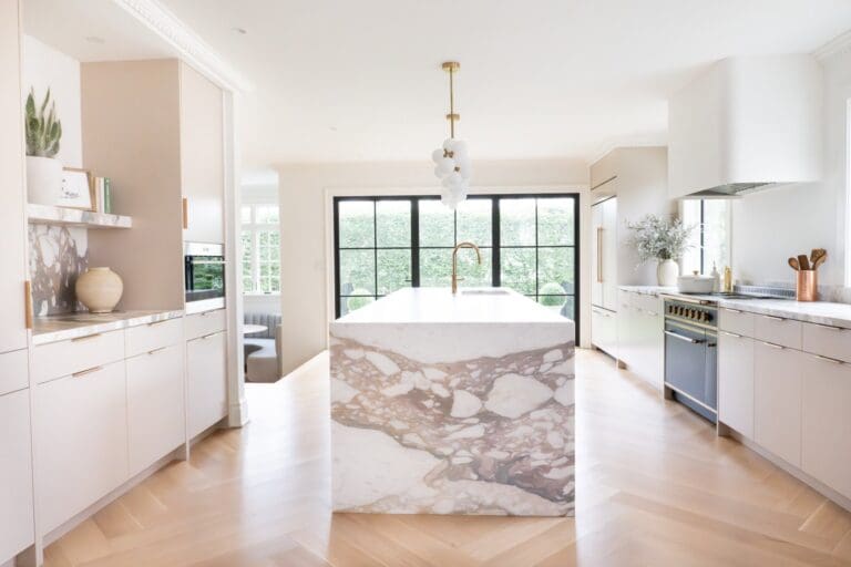 Two-tone custom kitchen cabinetry in New Jersey with a natural wood island, glass-front cabinets, skylight, and paneled storage for a high end kitchen design.