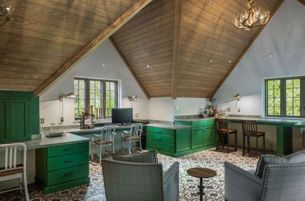 Custom home office cabinetry in Haverford, PA with green built-in cabinets, multiple work surfaces, and a vaulted wood ceiling.