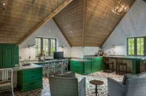 Custom home office cabinetry in Haverford, PA with green built-in cabinets, multiple work surfaces, and a vaulted wood ceiling.